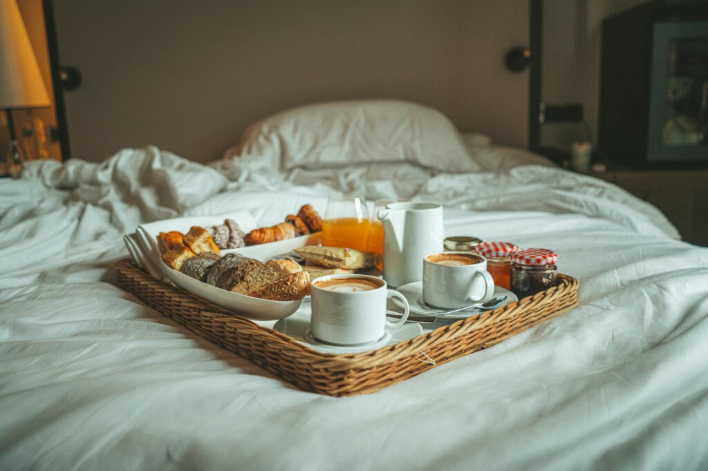Breakfast tray on a bed with white linen