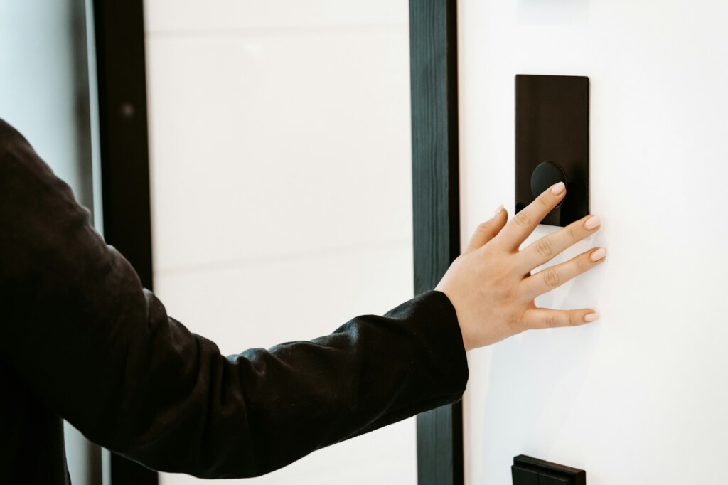 Guest using a smart access panel at a modern entrance for self check-in
